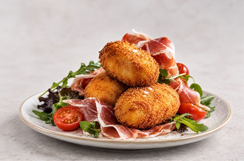 Croquetas artesanas de jamón ibérico con lonchas de jamón.