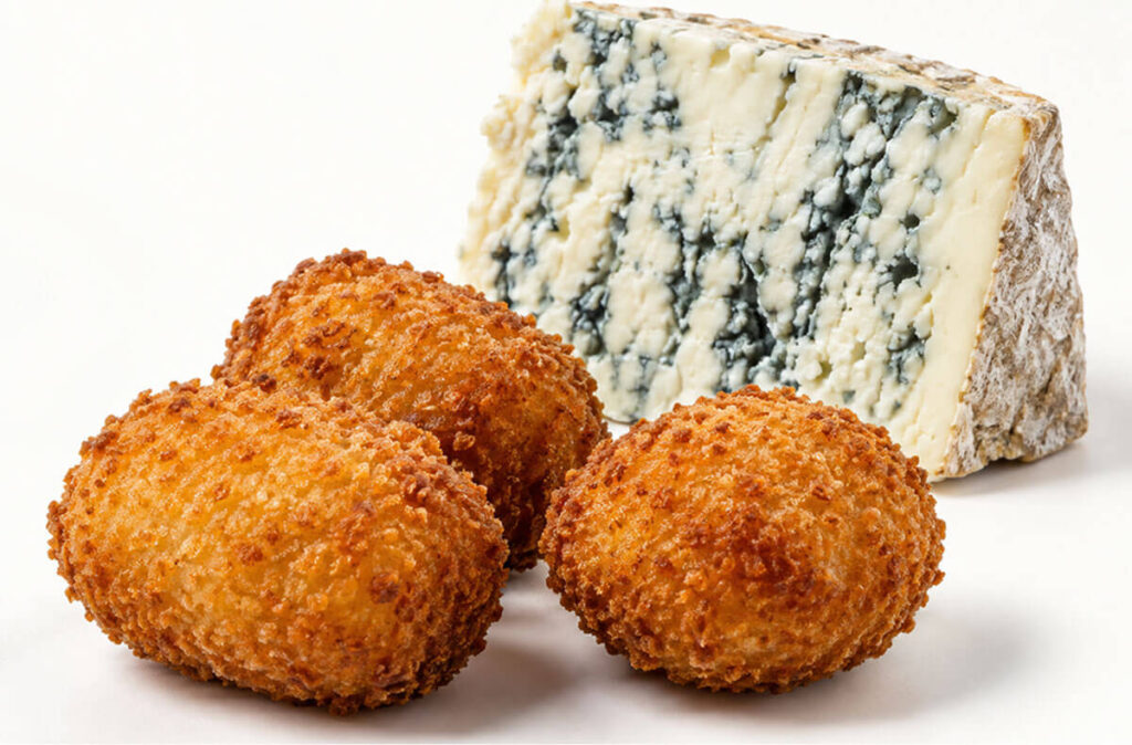 Croquetas artesanas de queso azul con cuña de queso.