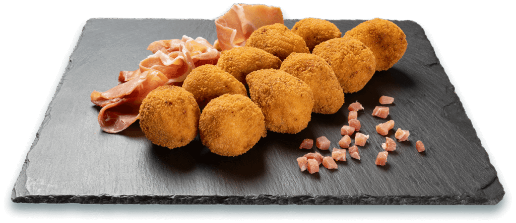 Croquetas artesanas de jamón sobre pizarra con jamón en lonchas y dados.