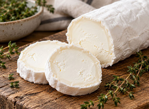 Queso de cabra en rulo, presentado entero y en rodajas.