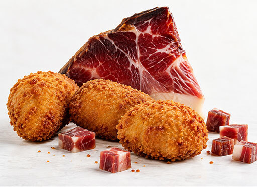 Croquetas artesanas de jamón de bodega con dados de jamón.